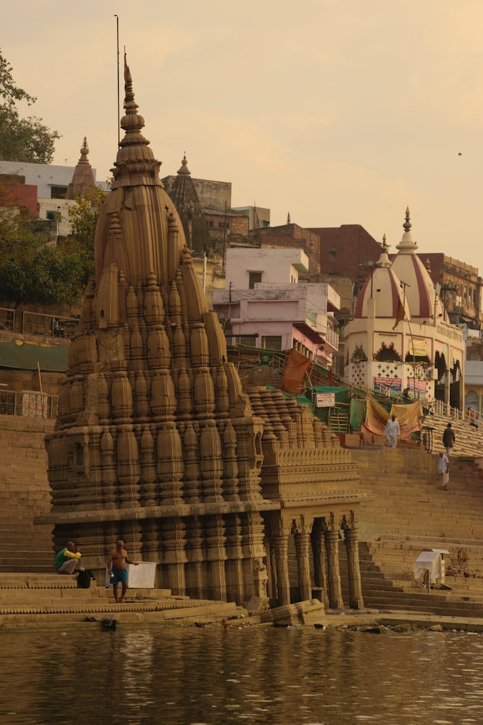 View of historic temples along the Varanasi riverbank, capturing ancient architecture against a vivid sky.