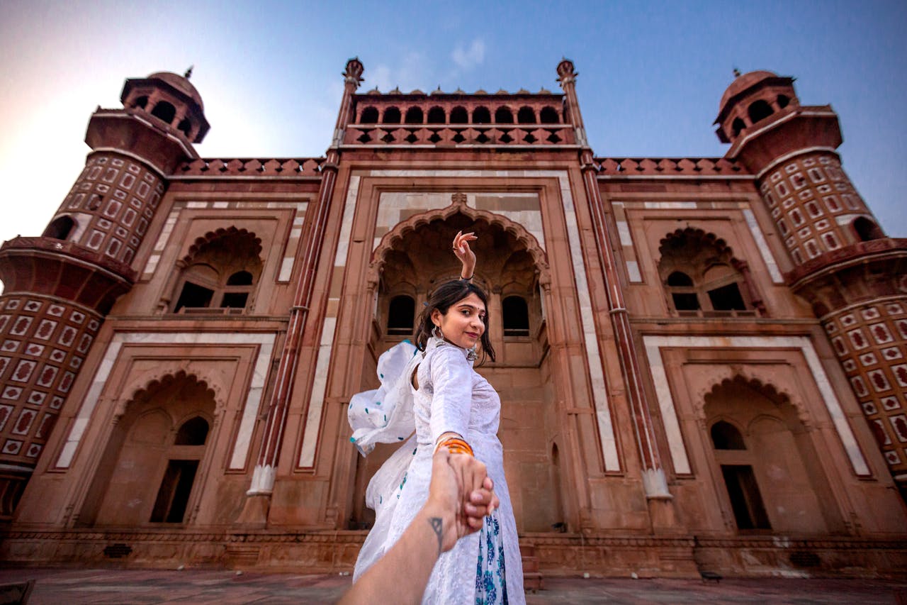 our-story A woman poses at a famous tomb in New Delhi, showcasing architectural beauty.