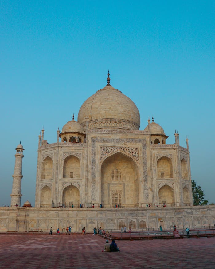 services-04 Ancient stone Taj Mahal with dome and fence located on square against blue sky in street in city in India